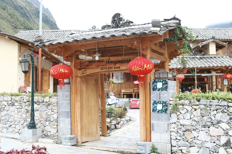 the entrance to a chinese - styled business with two lanterns hanging above