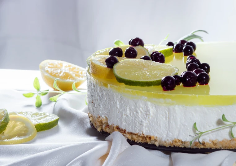 a cake topped with lemon slices and berries on top of a table