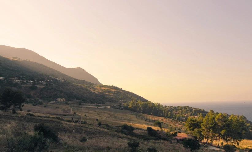 a scenic mountain is in the background, while many trees sit on a hill