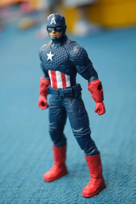 an action figure on the ground with red boots and blue shirt