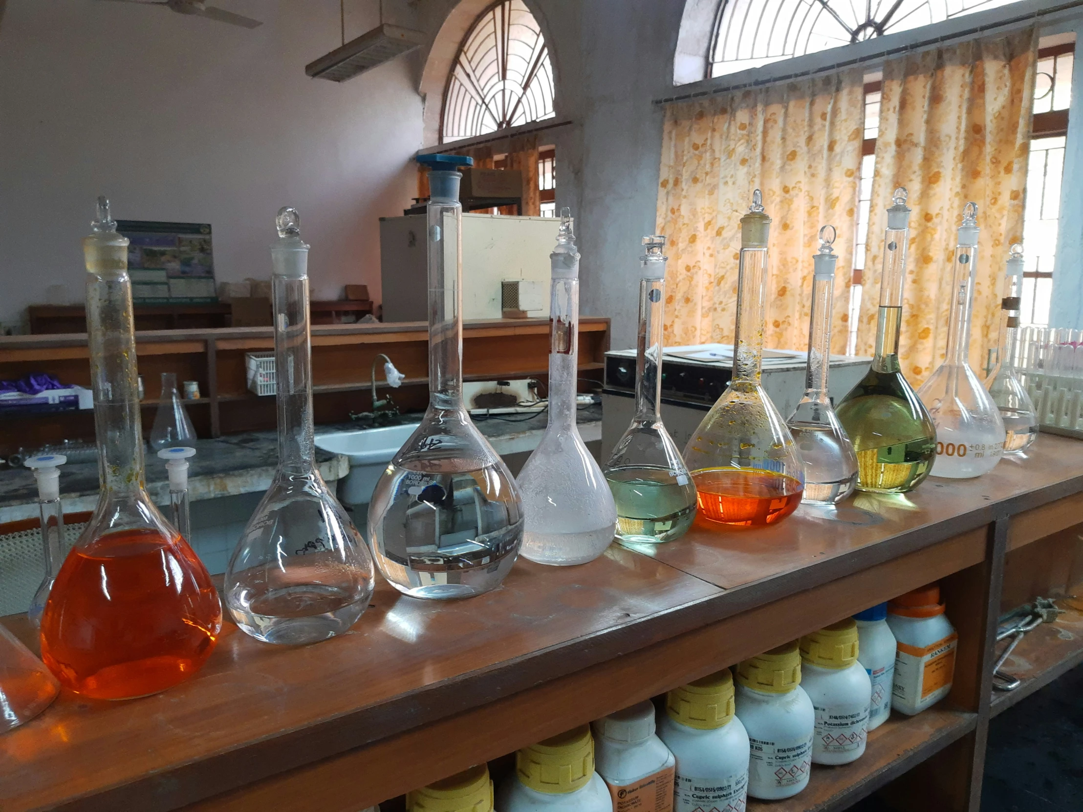 a counter topped with lots of bottles filled with liquid