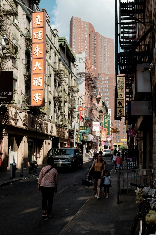 the people are walking on the street in front of buildings