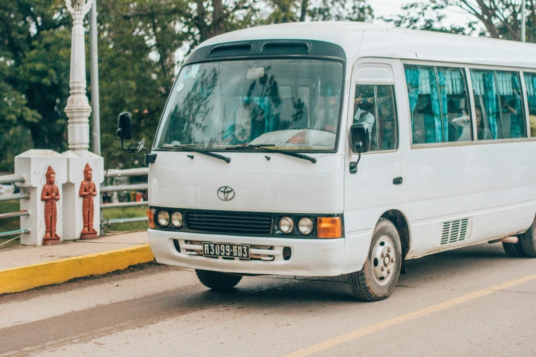 a white van driving across a bridge near a park