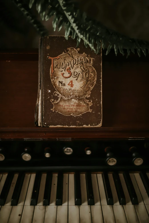 a close up of an old book next to a piano