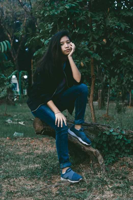 a young person leaning on a rock near a forest