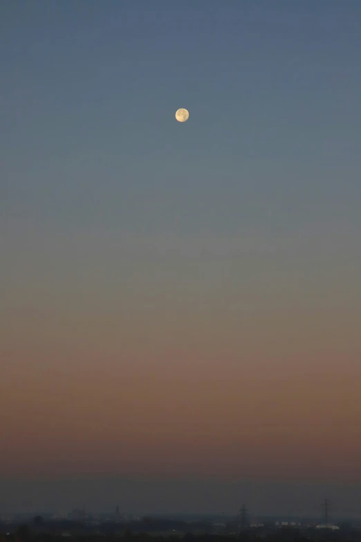 an image of a full moon taken from across the desert