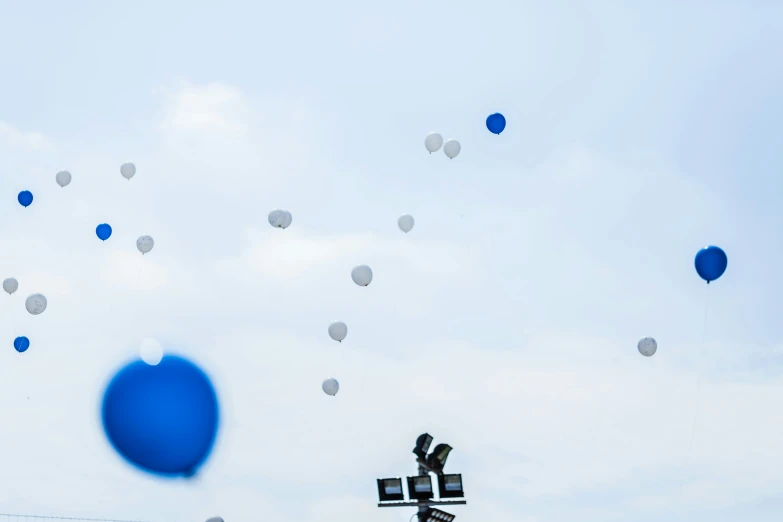 many blue balloons are flying high in the sky