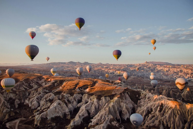  air balloons in the sky over rocky terrain