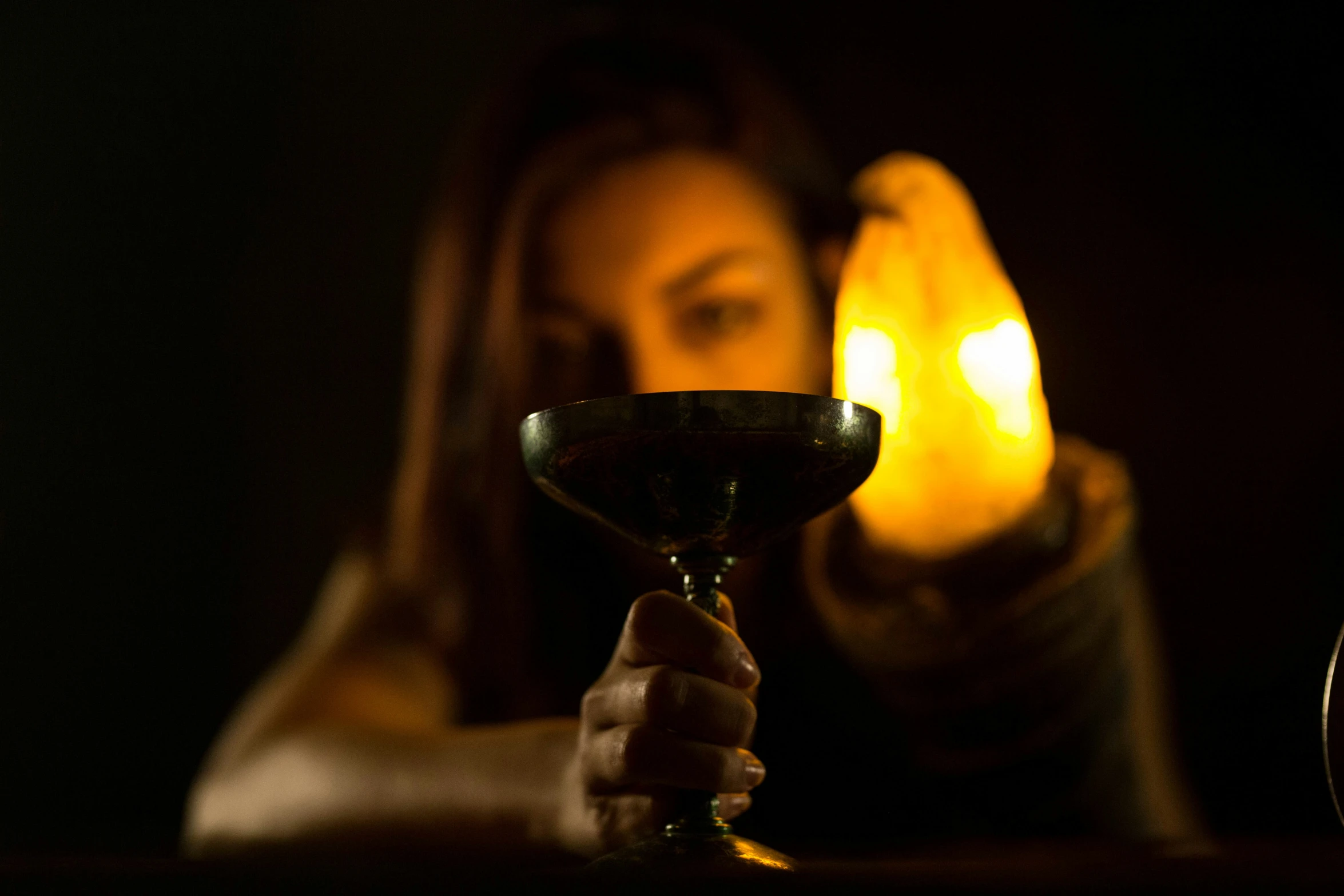 a woman holding up a wine glass on a table