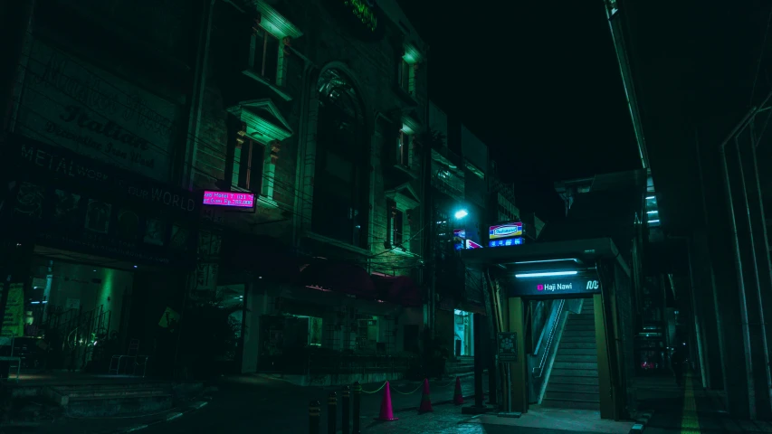 a city street at night with the door to the building on the left