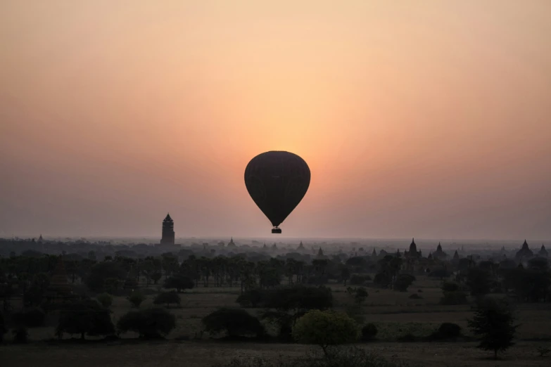 a  air balloon flying over a field in the sky