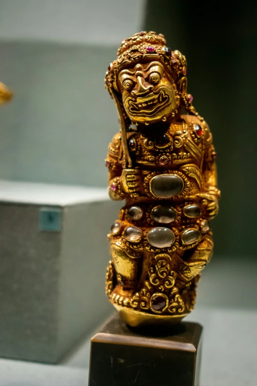 gold statue in museum with other statues