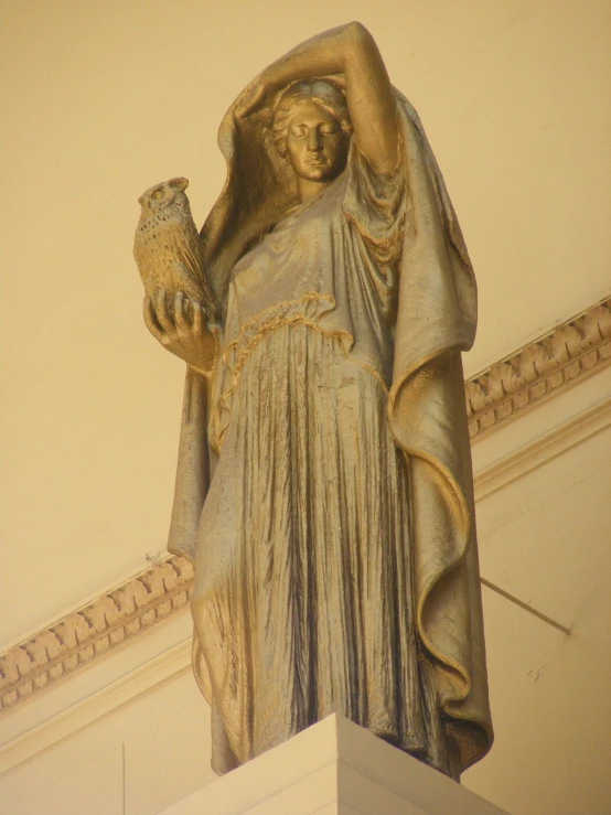 a statue with a bird on its arm