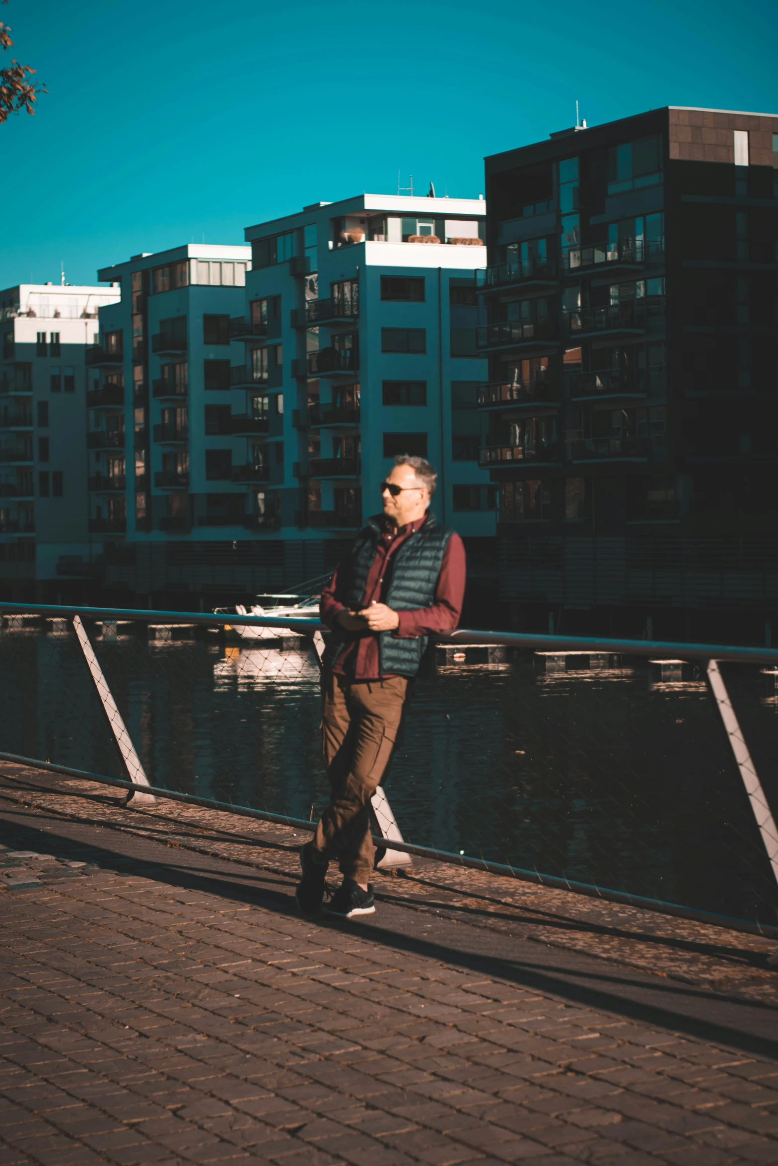 a man standing on a sidewalk in front of some buildings