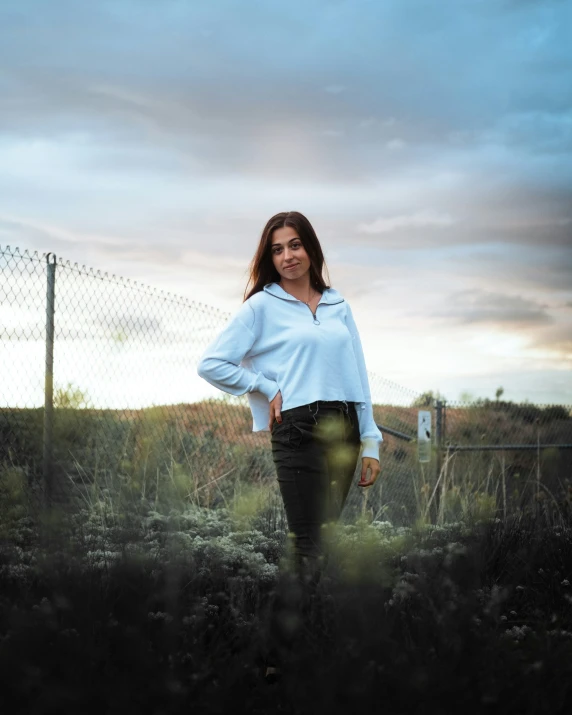 a woman standing in a field looking at the camera