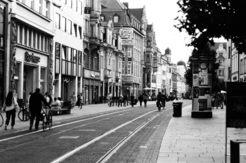 people walking down the side walk on a city street