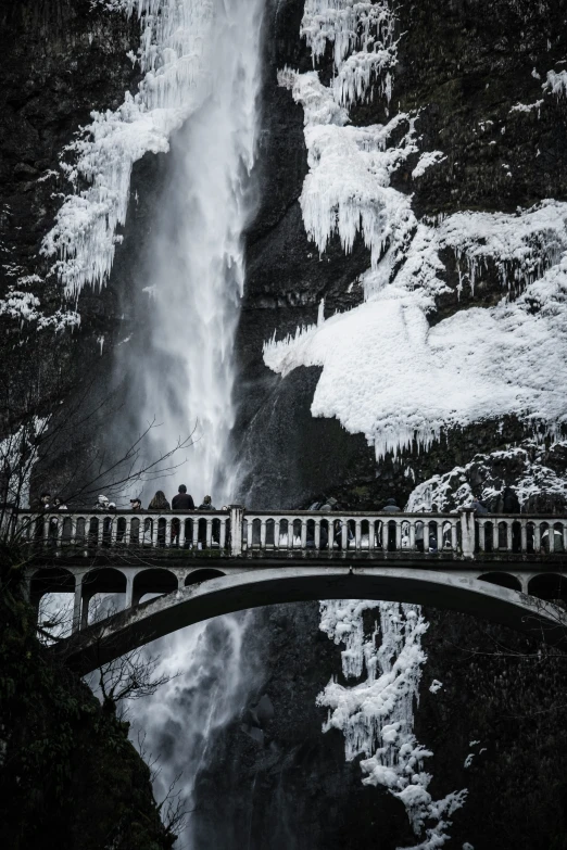 a bridge over a water fall with ice on it