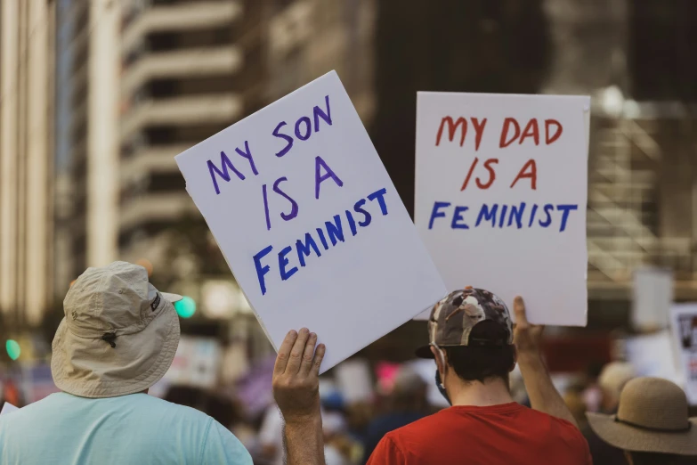 two people hold signs as they protest for their daughter
