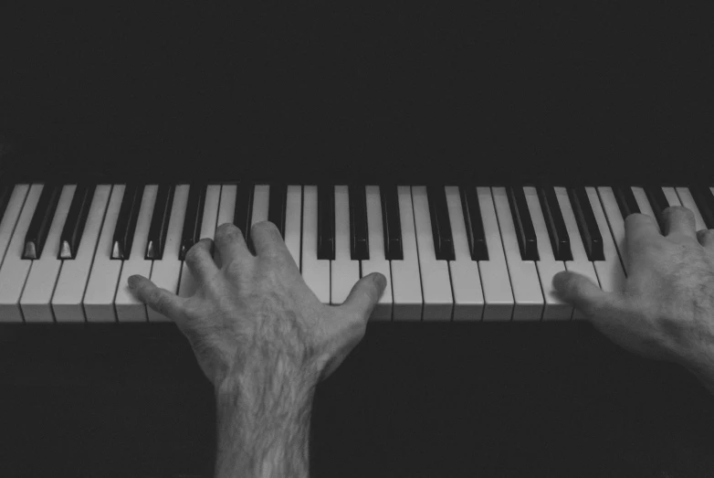 hands on a piano that's very close to the keyboard