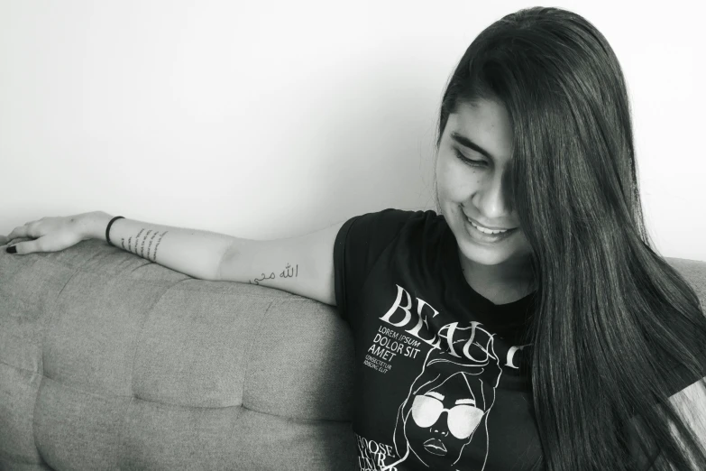 a young lady is smiling while sitting on the couch