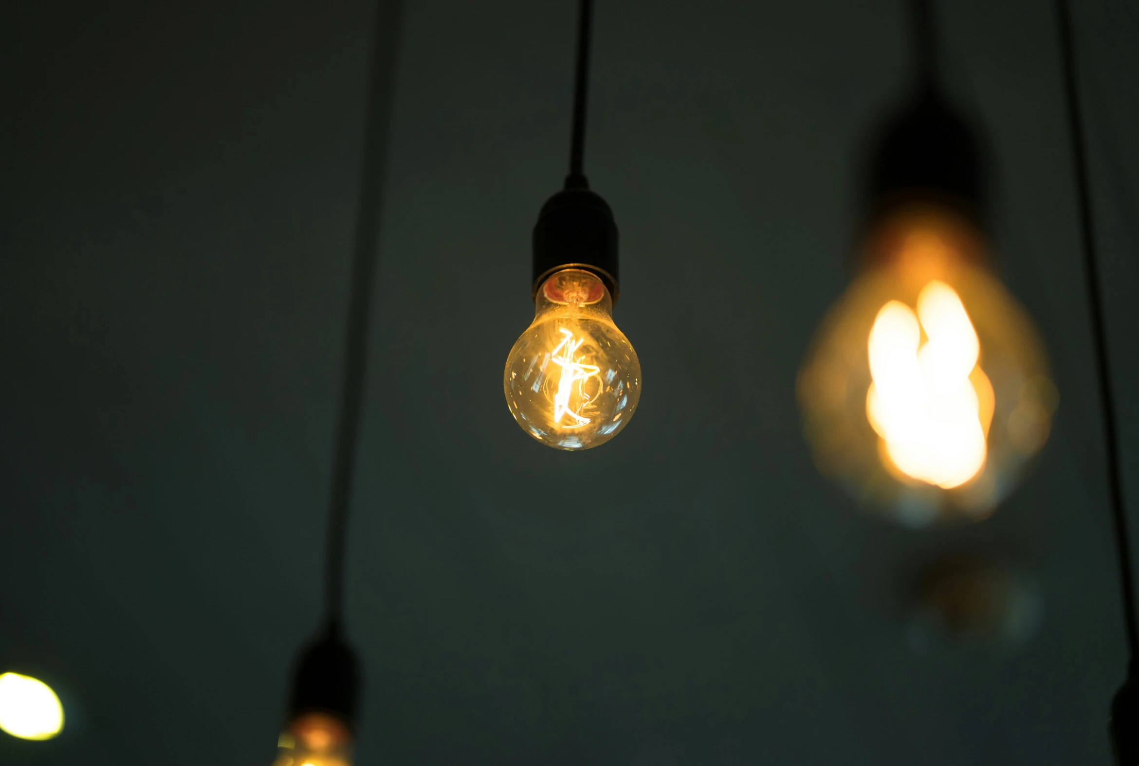 four light bulbs with some hanging lights in it