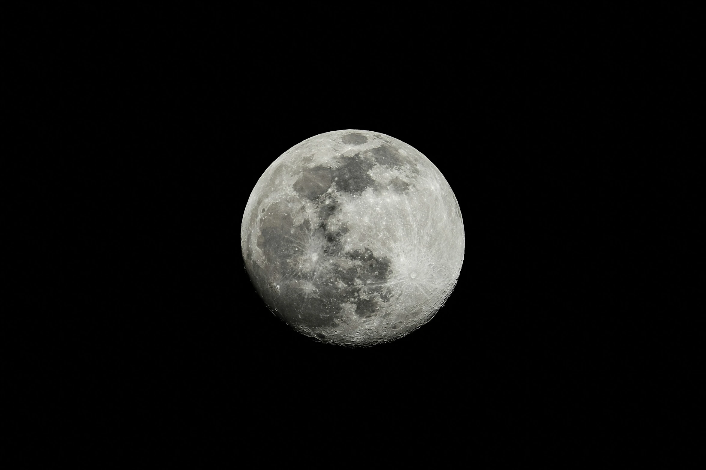 the moon is lit up in a dark sky