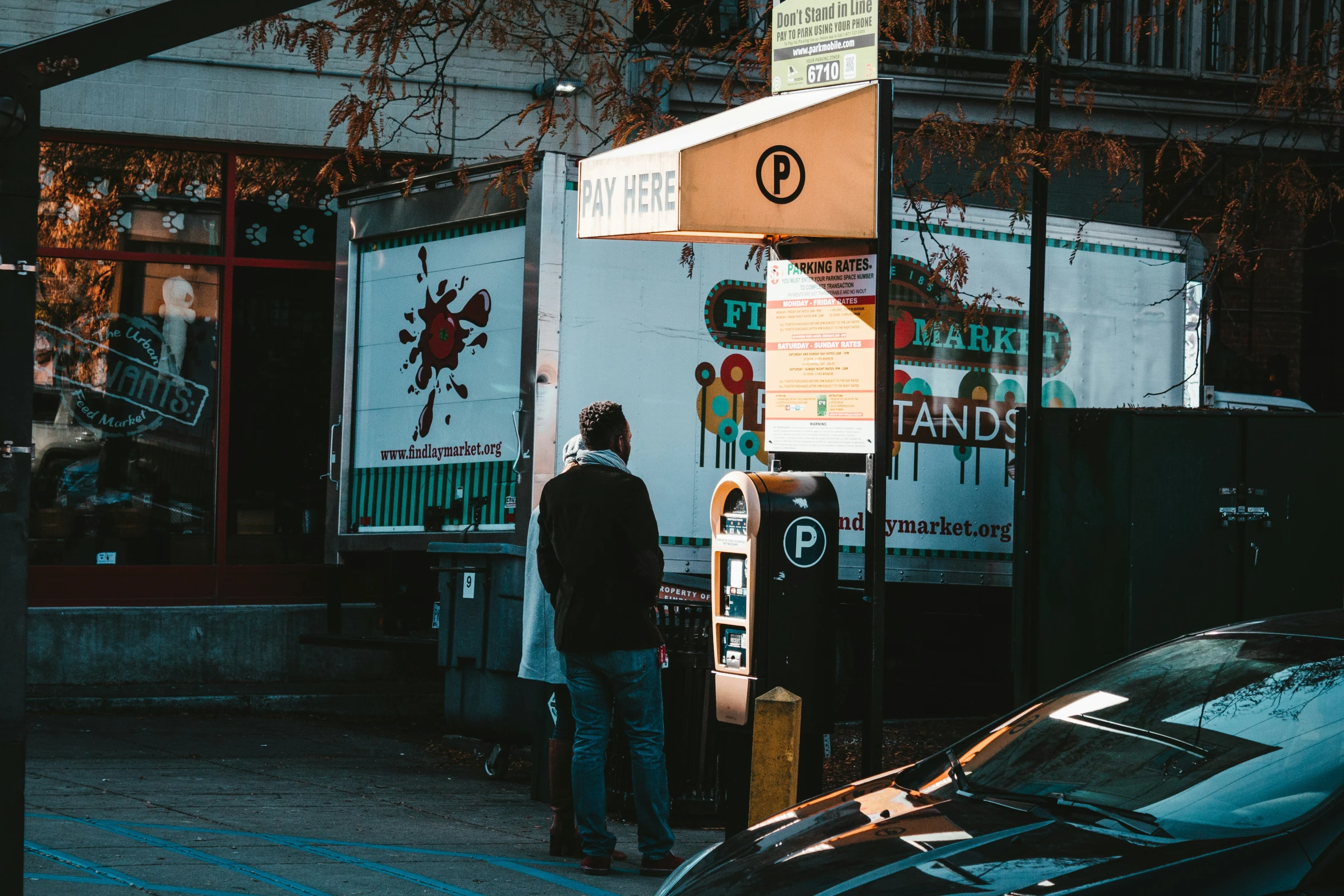 a man is using an atm machine at the curb