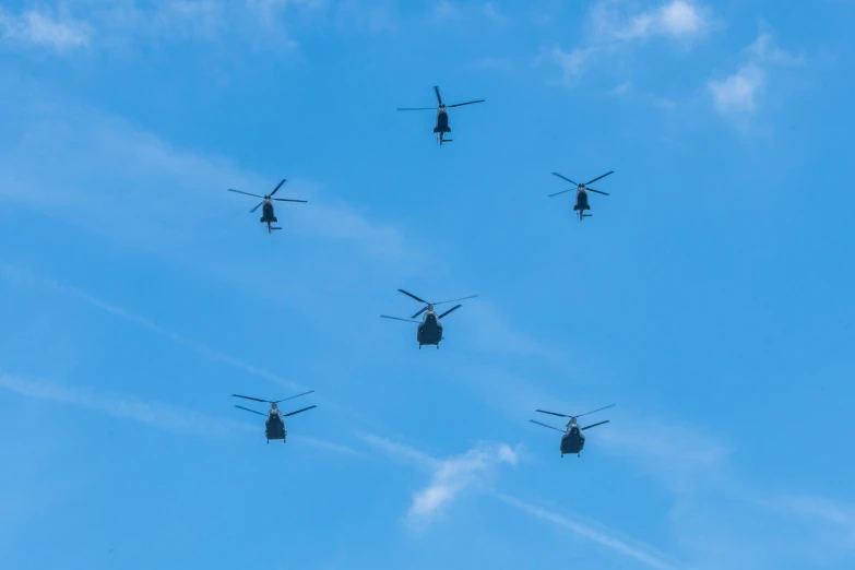 a group of helicopters flying in the sky on a clear day