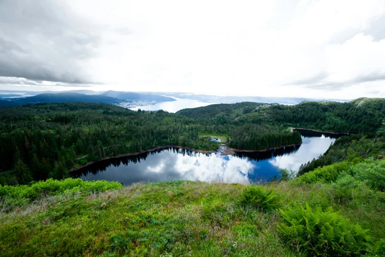 a lake surrounded by mountains in the middle of a grass covered field