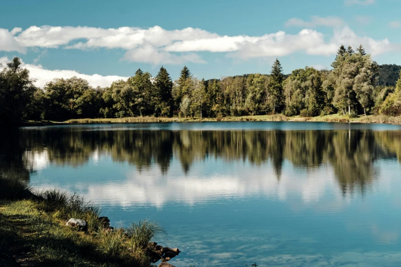 a mountain lake with clear blue water surrounded by trees