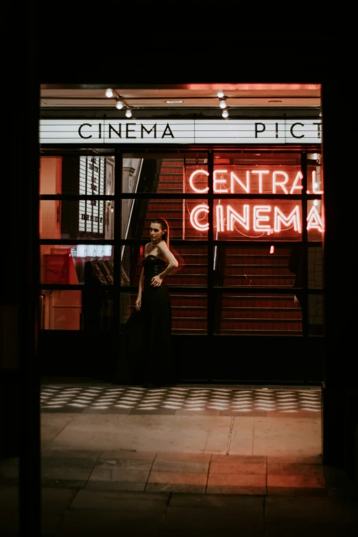 a man is outside a cinema sign