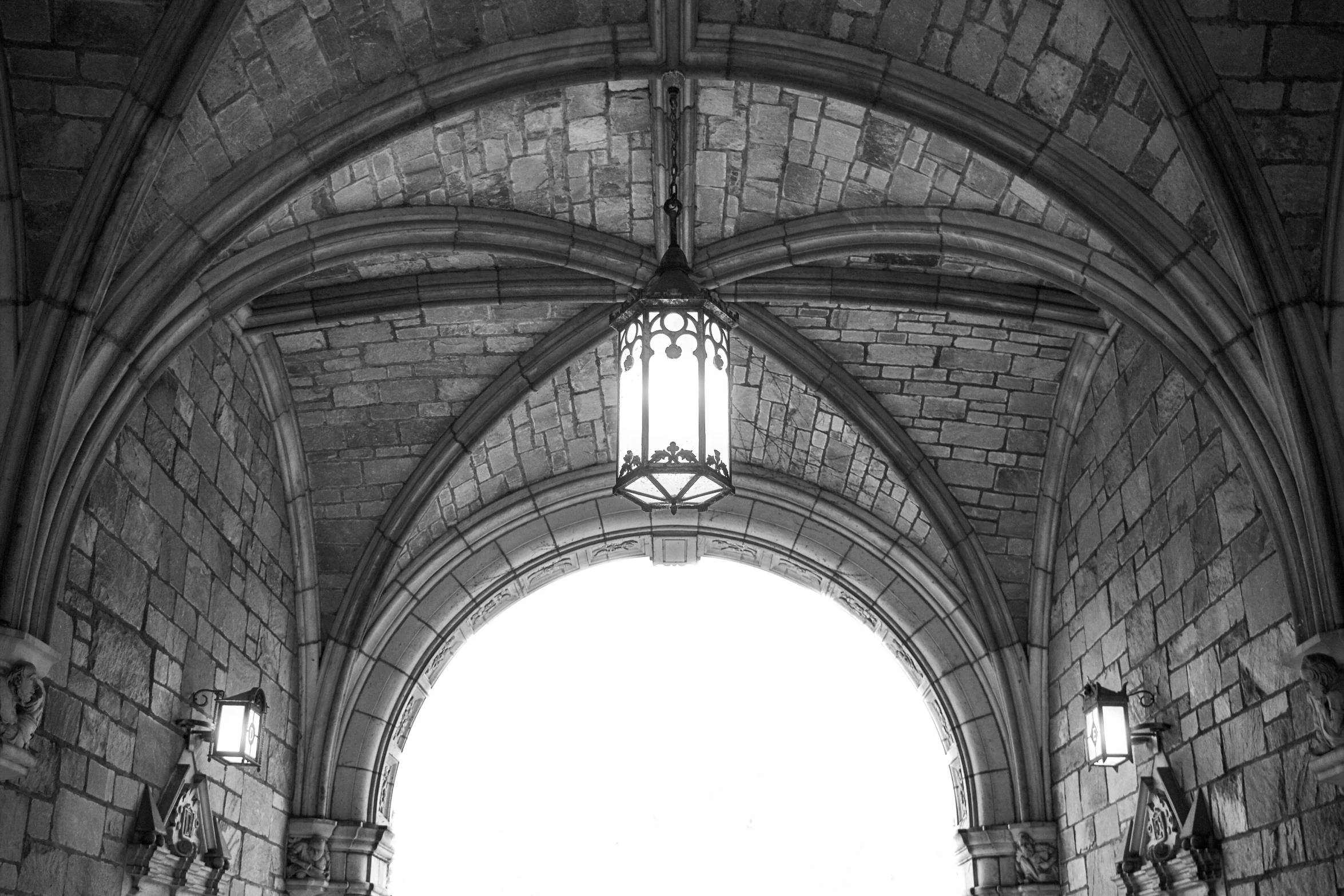 a large stone archway with several windows, and an open door leading into it