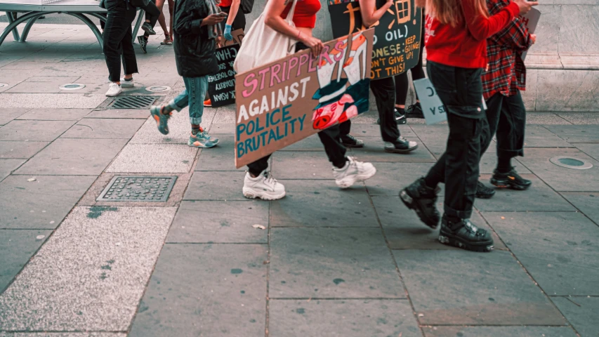 several young women walking in unison with signs on them