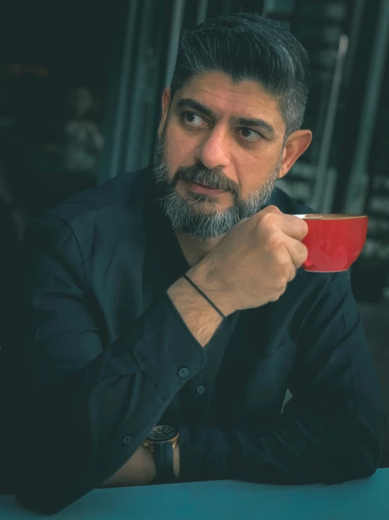 a man holding a red coffee mug in his hand
