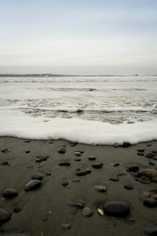 black and white rocks in the water at the beach