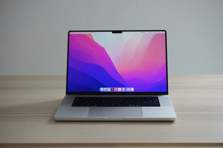 a macbook pro sitting on top of a wooden desk