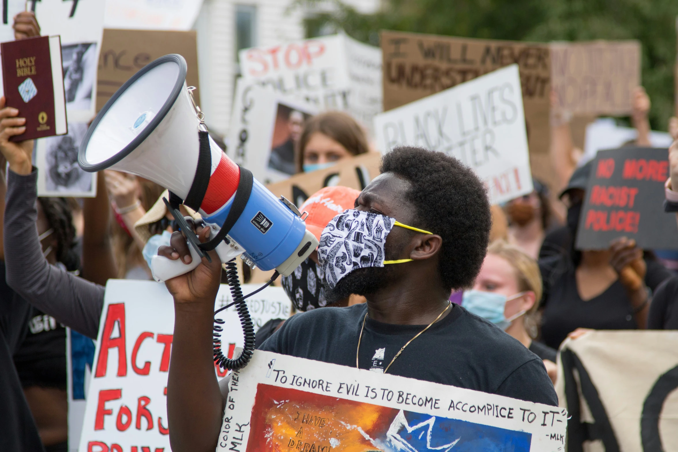 several people holding signs and bullhorns during a protest