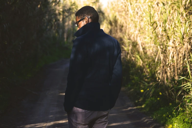 a man walking down a path holding onto his phone