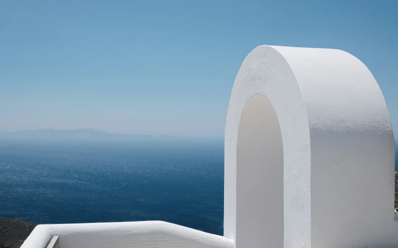 an unusual arch made from concrete overlooking the ocean