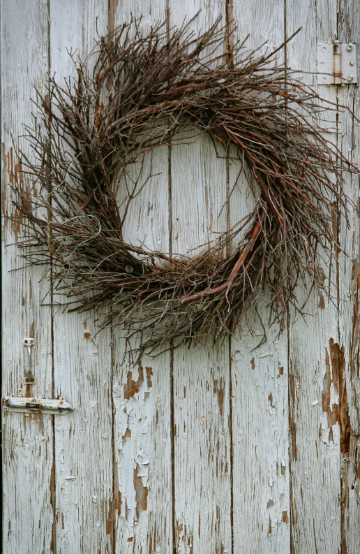 a rusty wreath that is lying on top of a door