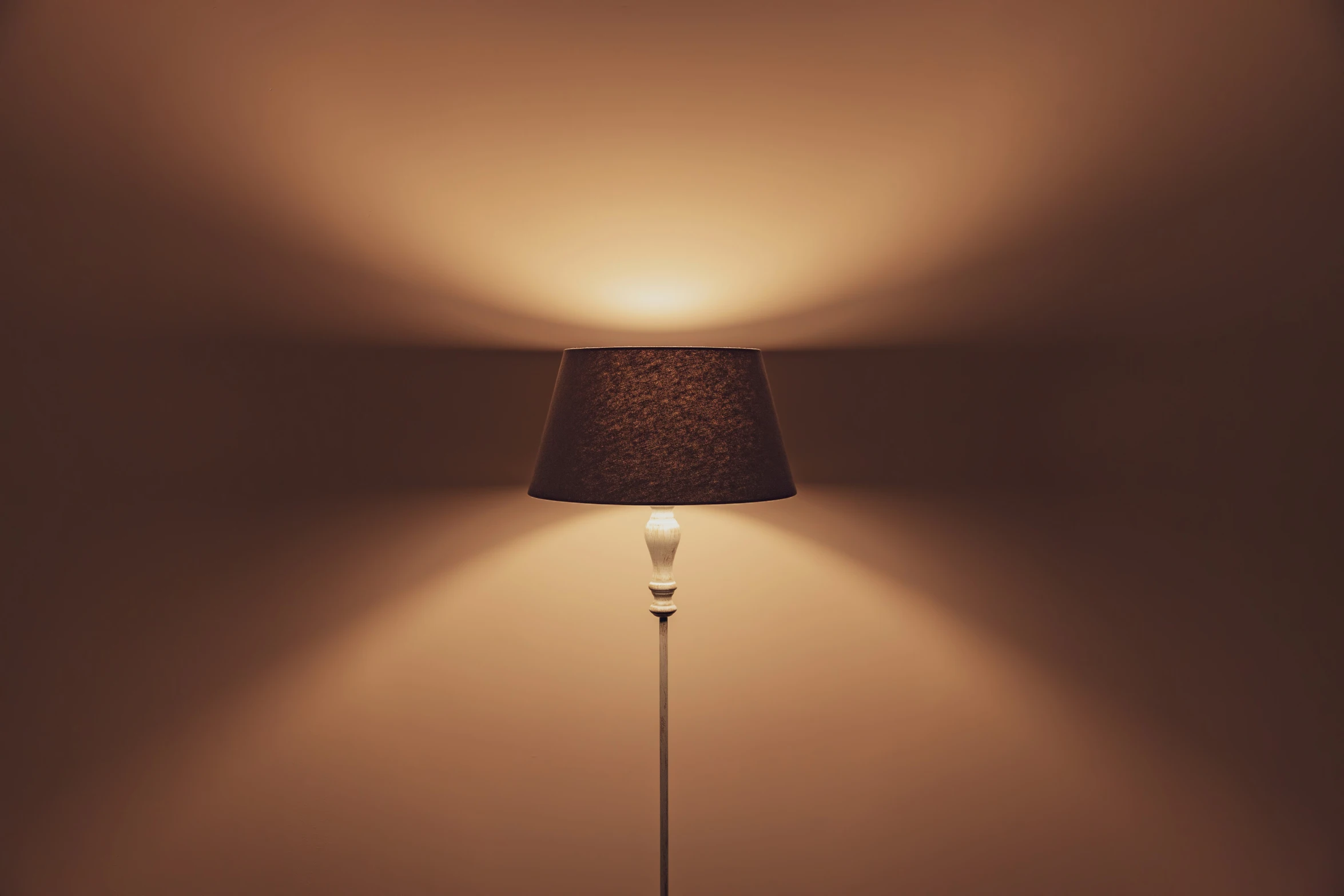 a lamp in a corner with a wall light on