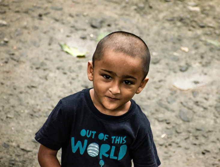 small child with t - shirt with blue and black design in front of him