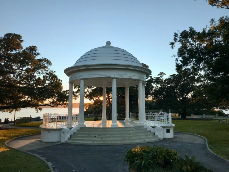 the white gazebo is very large and has pillars on each end