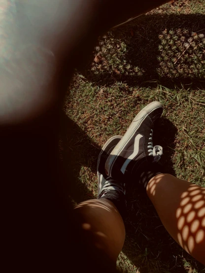 legs, shoes and a ball are visible while standing in the sun