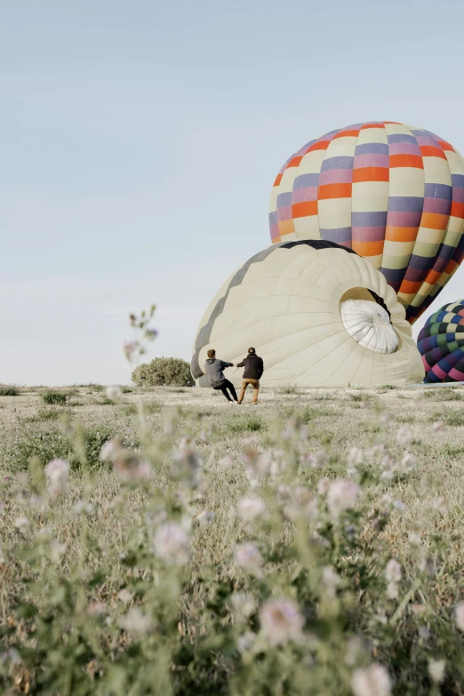 people that are in a field with some balloons