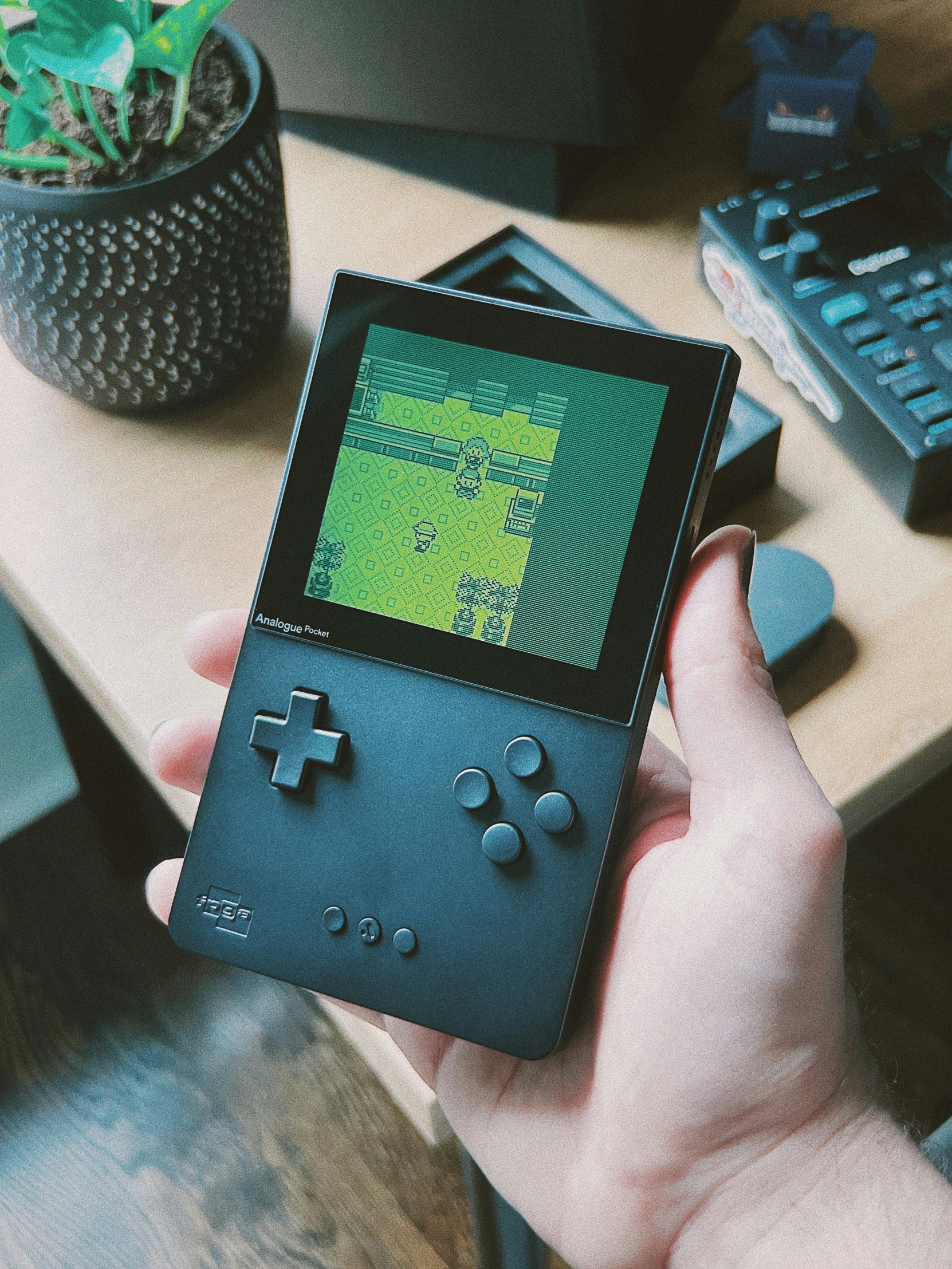 a gameboy being held in the hand by someone