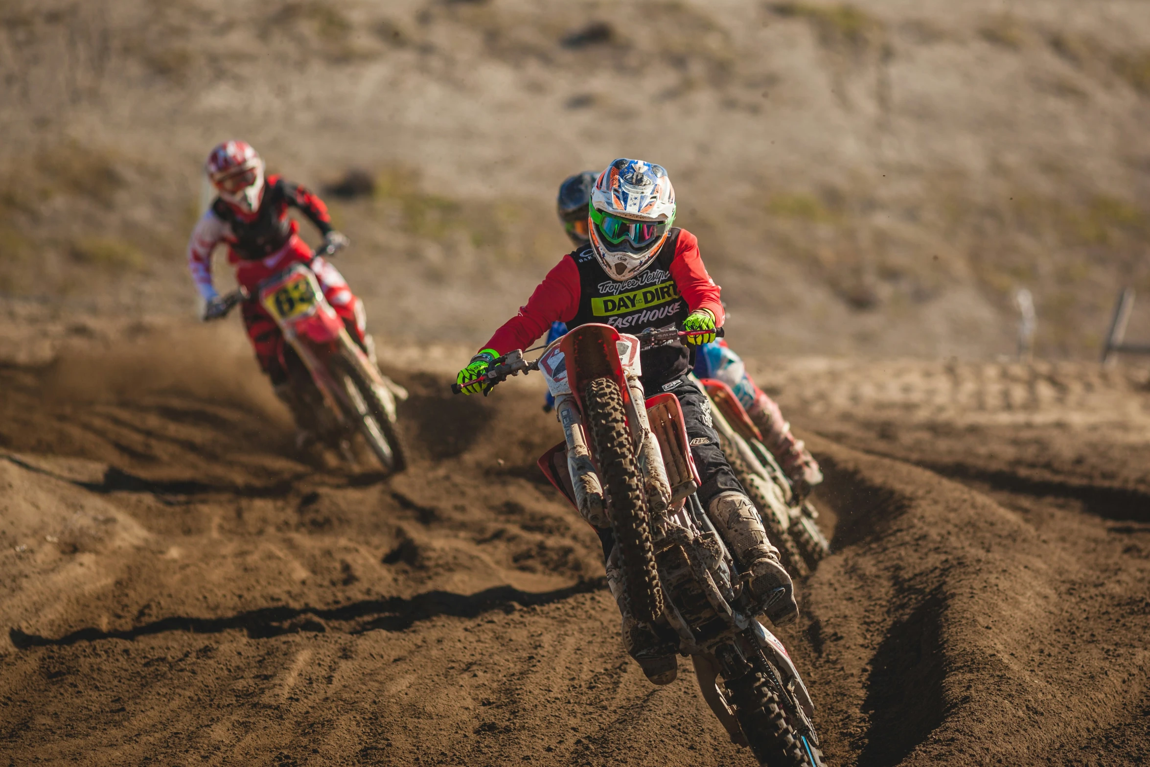 two men on dirt bikes going around a curve