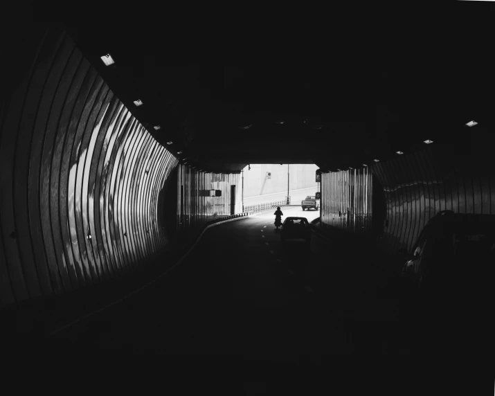 a dark tunnel is next to a man with his bike