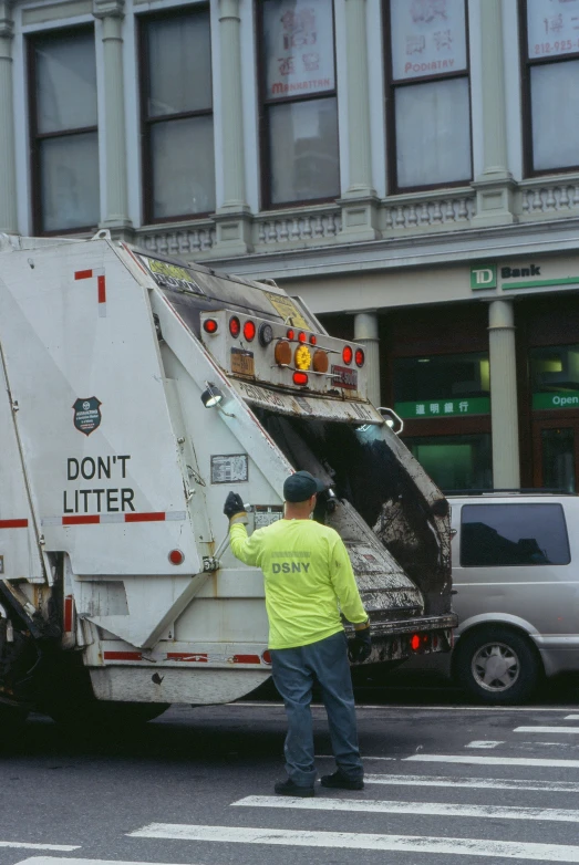 a garbage truck is parked by a bus