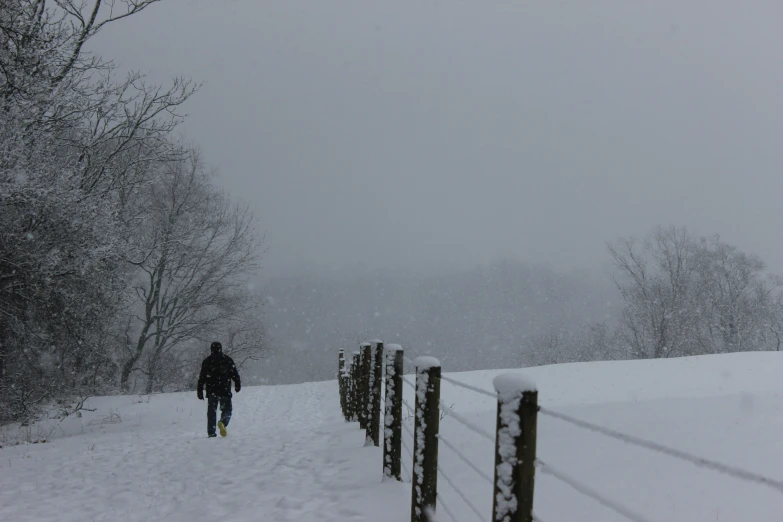 the person is walking down the snow - covered path